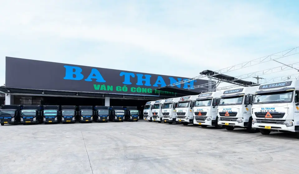 Đội xe tải giao hàng Ba Thanh xếp hàng trước nhà kho