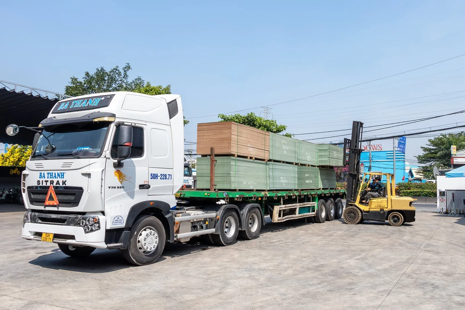 Xe nâng bốc ván gỗ lên xe tải container tại kho Ba Thanh