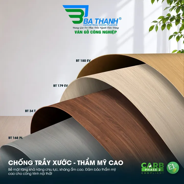 Ảnh quảng cáo Ba Thanh: bốn tấm bề mặt vân gỗ uốn cong, mã BT 180 EV, BT 179 EV, BT 34 T, BT 168 PL — Chống trầy xước, thẩm mỹ cao; bề mặt tăng khả năng chịu lực, kháng ẩm cao; trên poster có logo CARB Phase 2 và E1 (cấp phát thải đi theo cốt ván chọn kèm — tiêu chuẩn E2, hoặc E1 / CARB P2 / E0 tuỳ cốt; lớp phủ Melamine không mang cấp riêng)